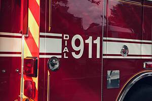 Close-up shot of a firetruck's door featuring the 911 emergency number.