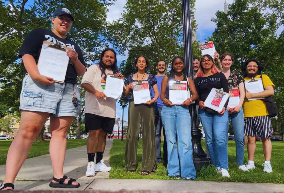 Elizabeth residents holding up clopboards with petitions