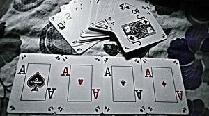 A close-up view of playing cards showing four aces, symbolizing a winning hand in poker.