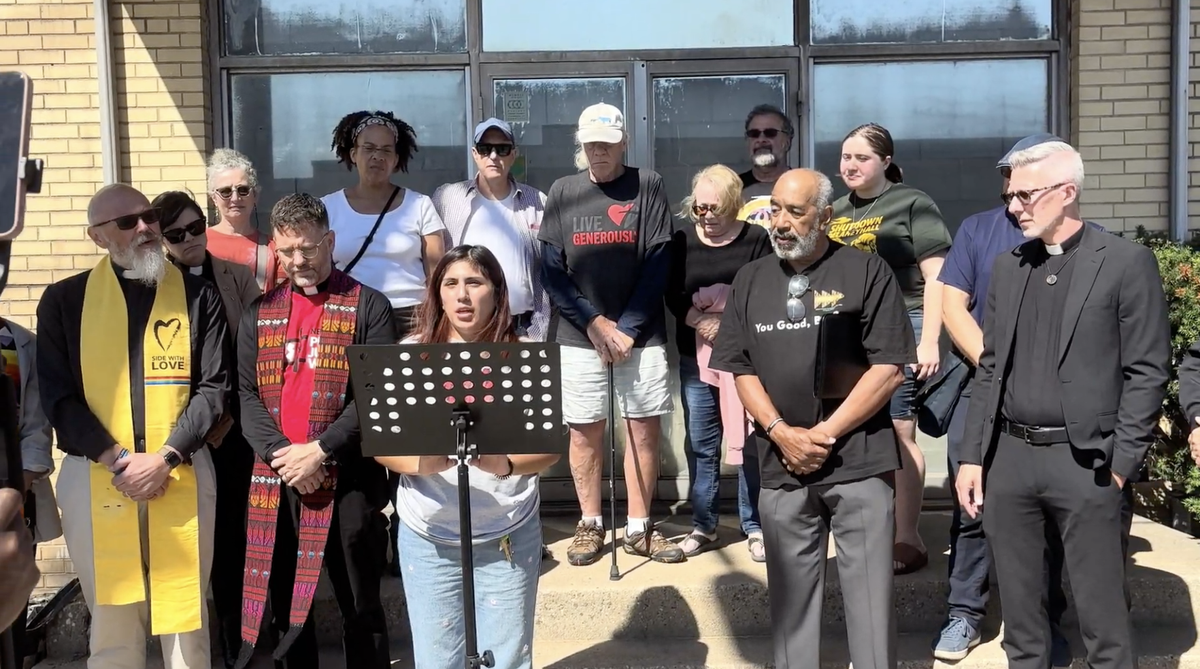 Woman standing behind podium with clergy.